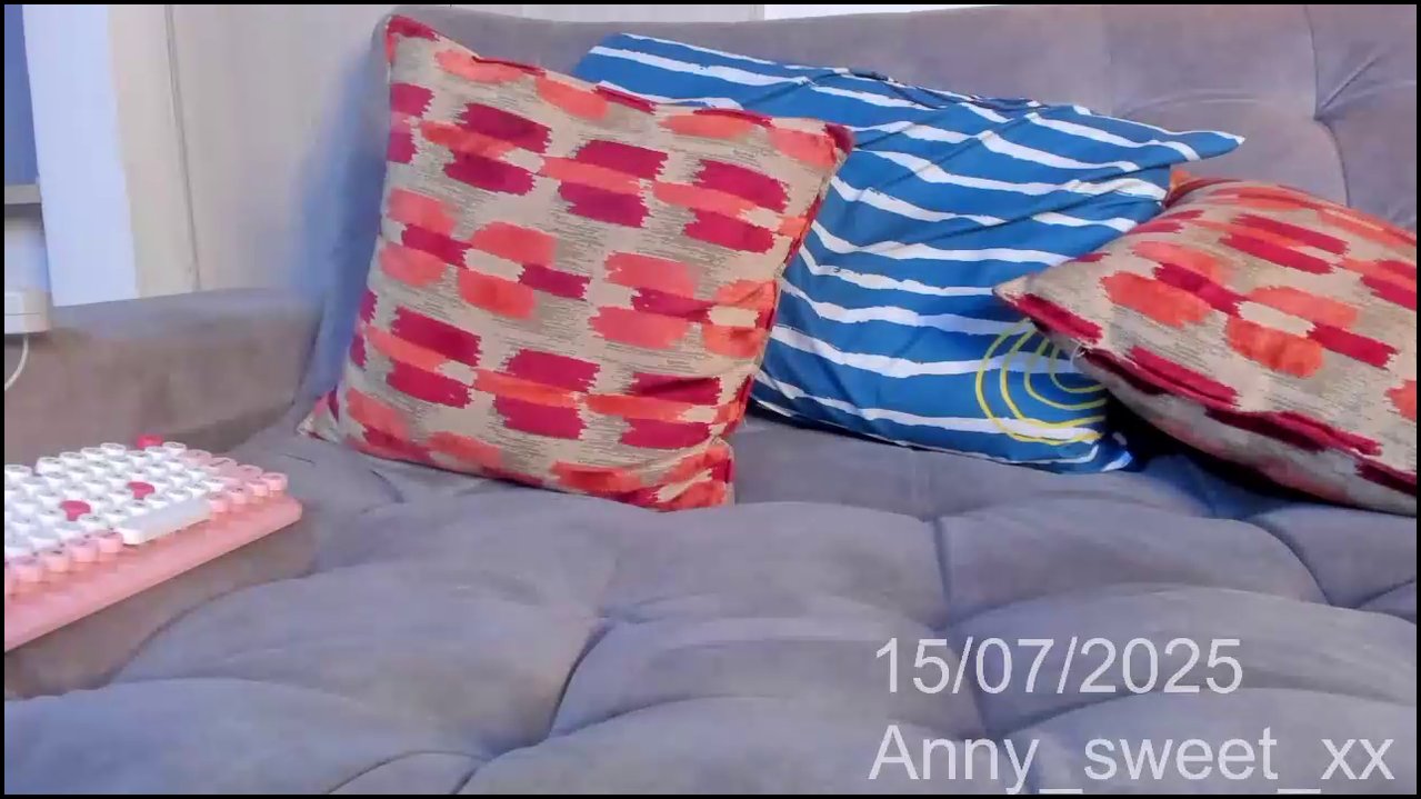 Video of a transgender woman with long brown hair, wearing a black lace bra and fishnet stockings, spreading her legs to reveal her erect penis.