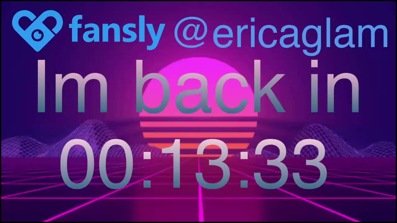 A young transgender woman with fair skin and brown hair, wearing a floral nightgown, sits in a chair, masturbating, with a penis visible. The room is 